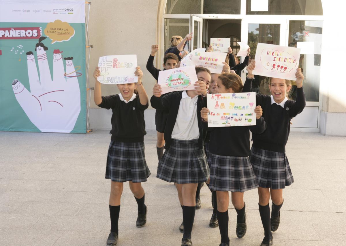 En la imagen un grupo de niñas portando carteles solidarios alusivos al Concurso escolar ONCE