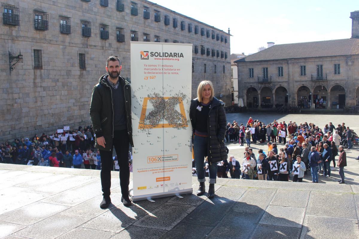 Iker Sertucha, presidente do CERMI galego e Mónica Permuy, de EAPN-Galicia  sostendo unha pancarta da campaña da X Solidaria na Praza da Quintana de Compostela