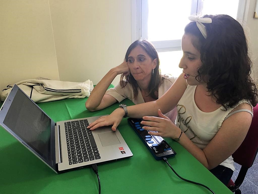 A conselleira atende ás explicacións de Lucía Álvarez sobre o funcionamento dun equipo informático adaptado para persoas cegas