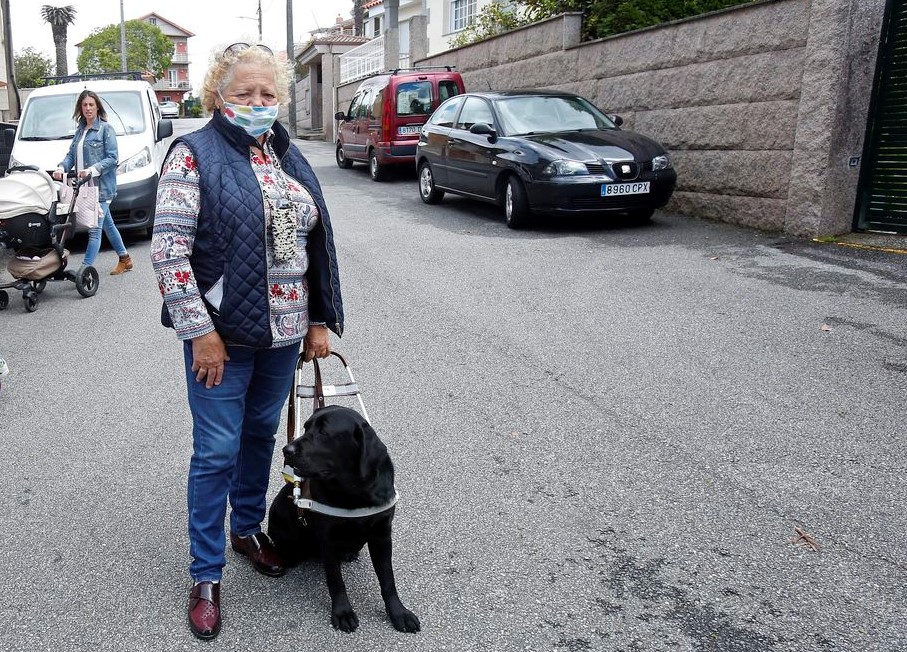 Imagen de Carmen Gómez y su perra Stella a las puertas de su casa en Portonovo-Pontevedra