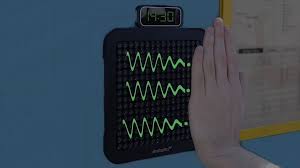En la imagen se ve la mano de una persona orientada hacia un emisor de ultrasonidos que permite leer braille sin contacto