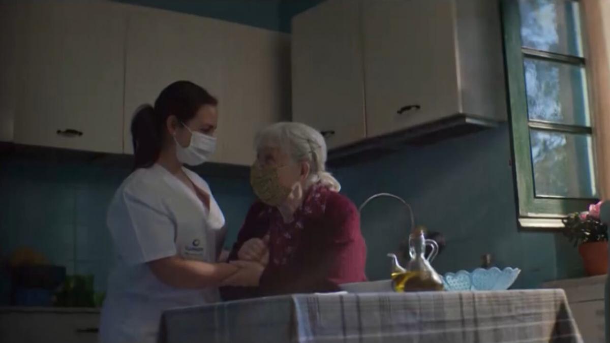 Fotograma de la campaña en la que aparece una joven cuidadora atendiendo a una anciana en su casa