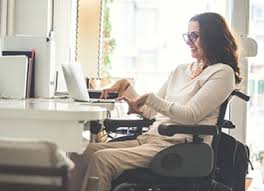 Fotografía de una mujer joven tetrapléjica trabajando desde su ordenador portátil
