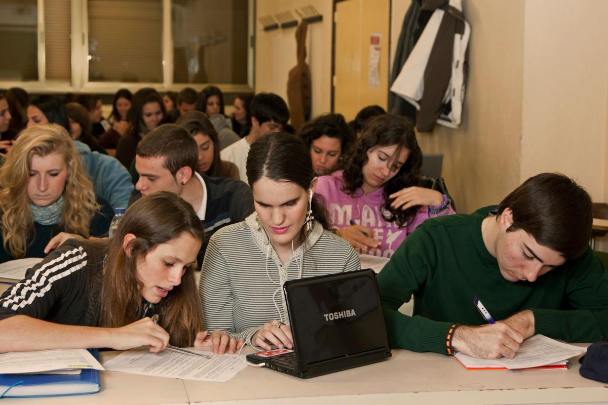 Una estudiante con discapacidad visual en el aula de la Universidad rodeada por sus compañeros