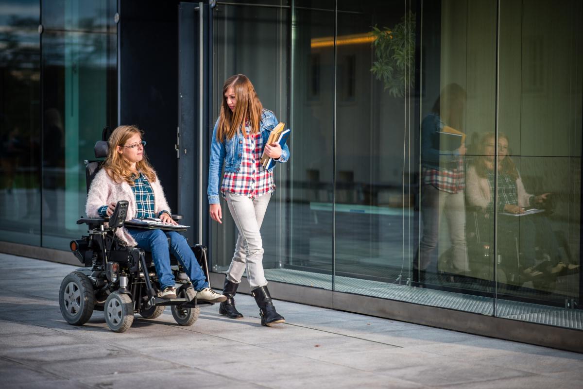 Dos alumnas universitarias, una de ellas con discapacidad, a las puertas de un centro universitario