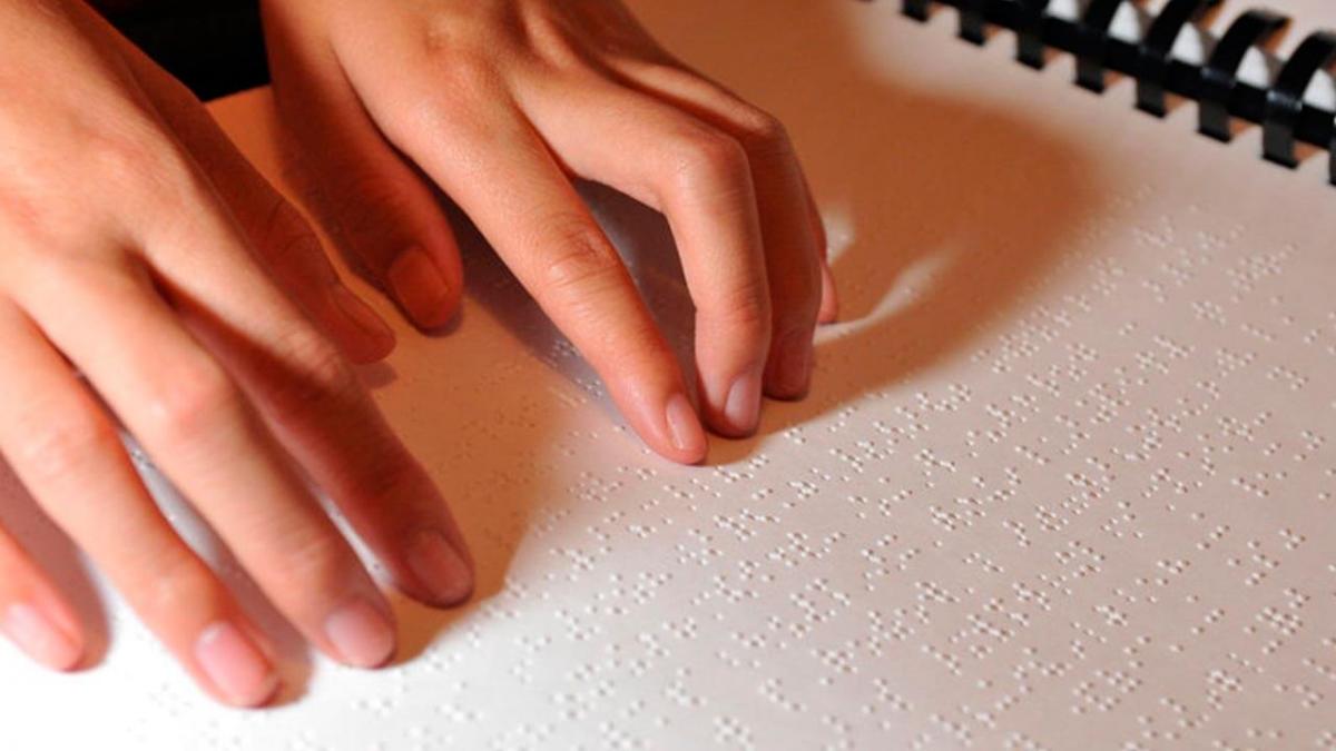 Unhas mans de muller len un libro es braille