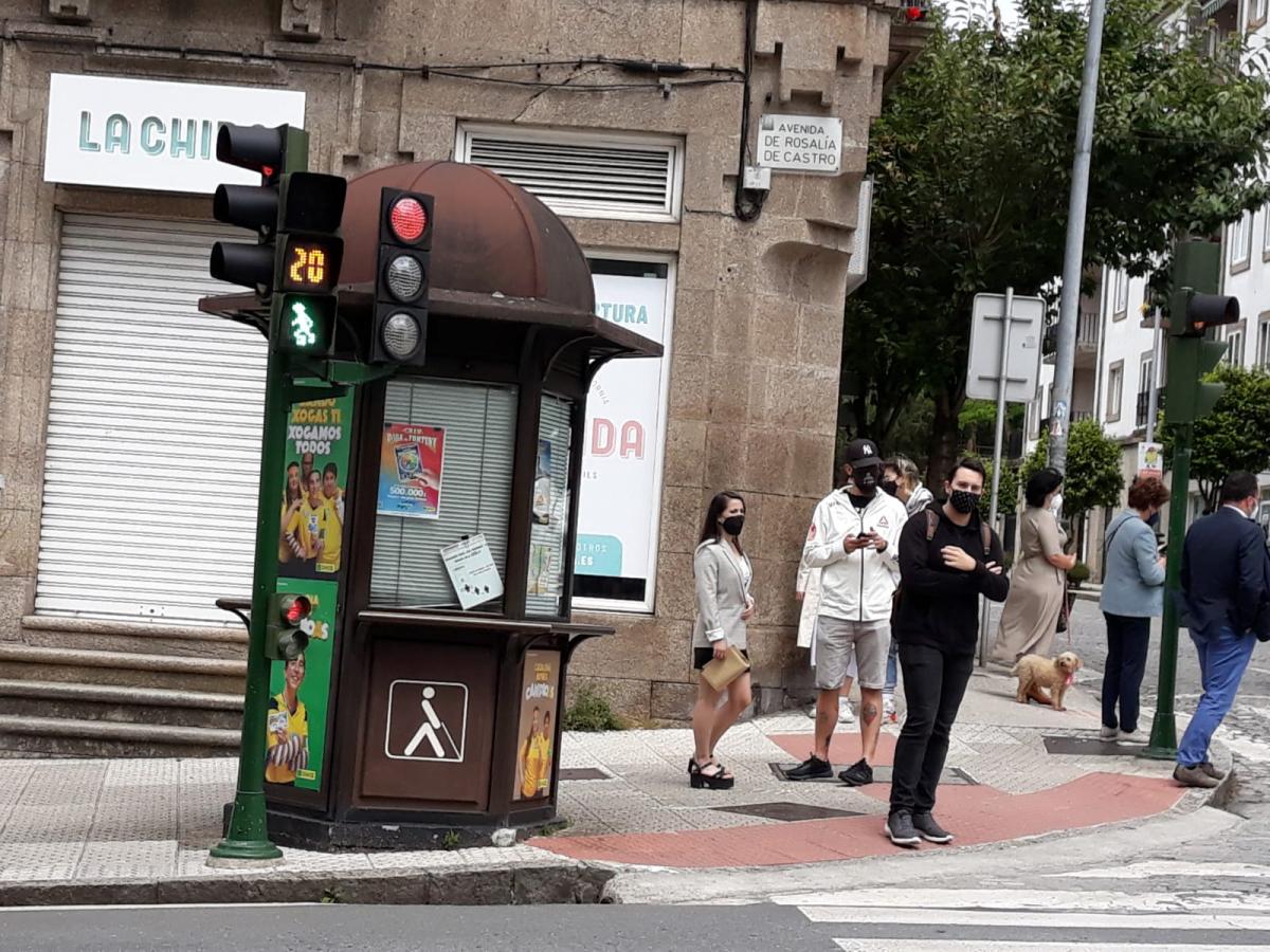 Imagen de un semáforo de Santiago, con un kiosco ONCE detrás, en la confluencia de las calles Rosalía de Castro y  Avenida de A Coruña