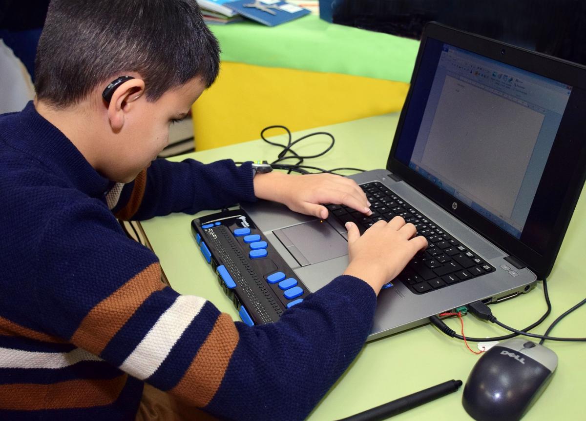 Un niño sordociego trabajando con adaptaciones tecnológicas