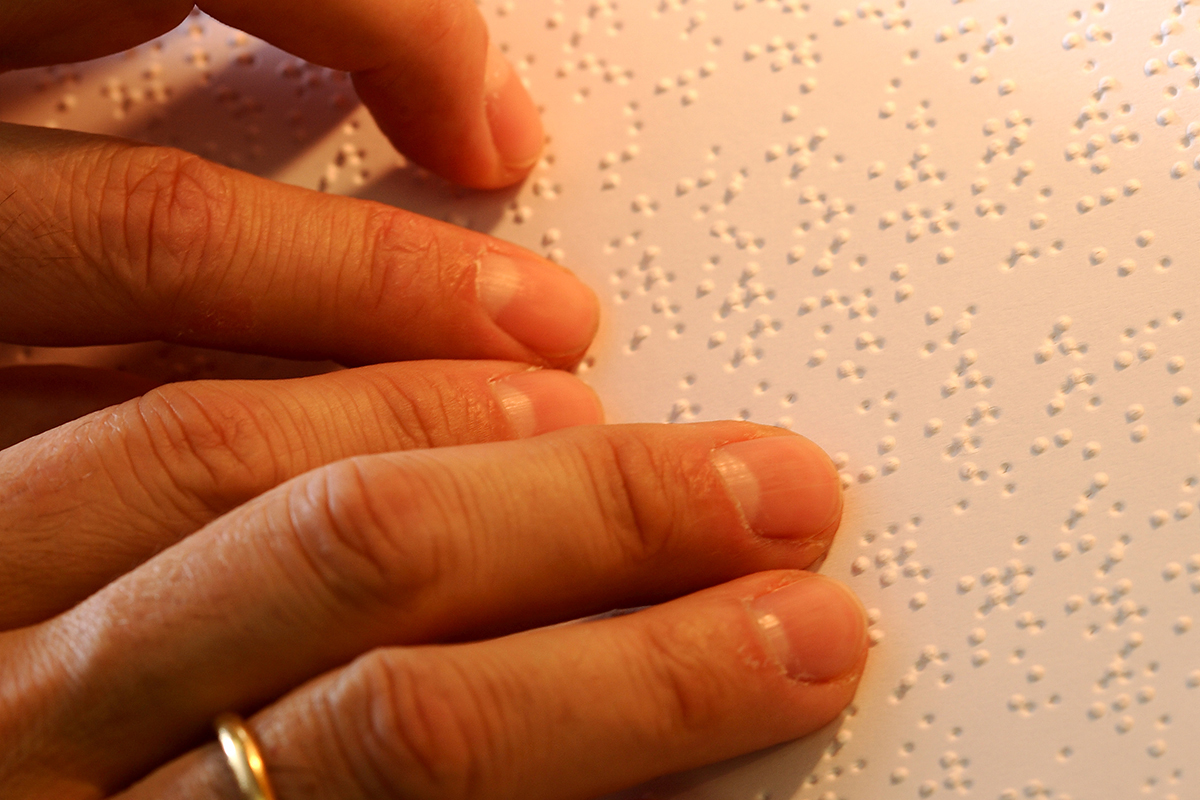 Manos sobre un texto braille