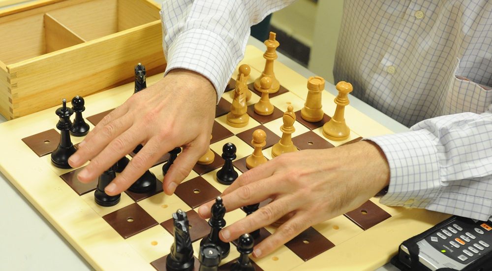Manos sobre un tablero de ajedrez adaptado