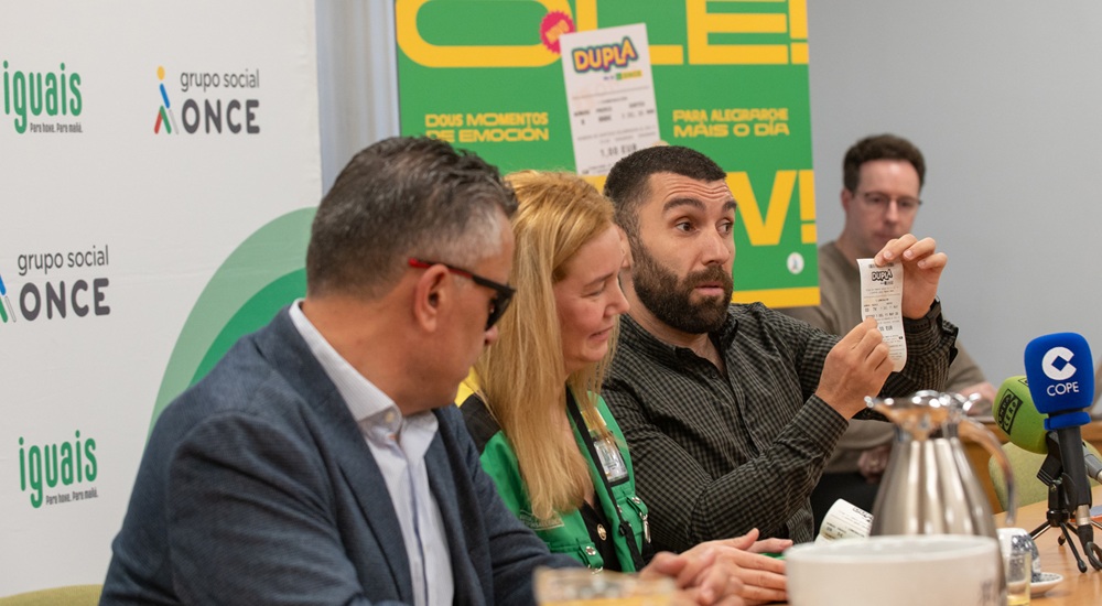Adrián González muestra un boleto de Dupla, junto a Manuel Martínez Pan y la vendedora de la ONCE Izabel  Cristina Dos Santos