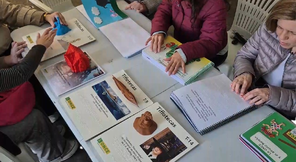 Un grupo de personas ciegas leyendo libros en braille durante la Feria del Libro de Santiago