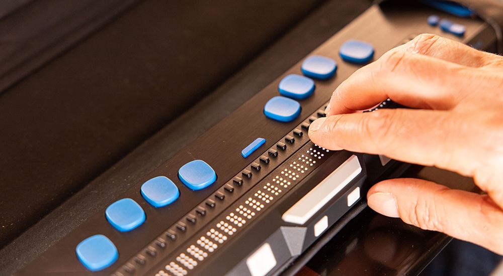 Detalle de una mano utilizando una línea braille