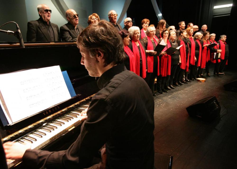 Palo Méndez ao piano mentres dirixe ao coro
