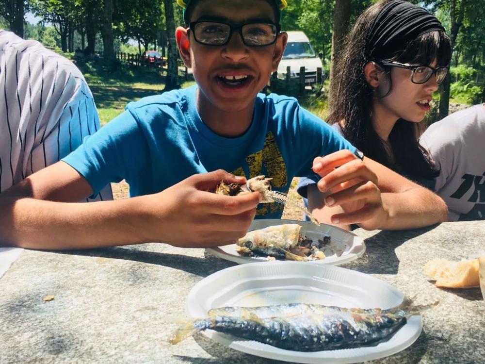 Dos jóvenes comen sardinas 