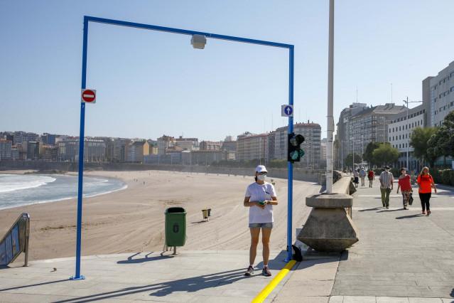 Fotografía del verano de 2020 con los arcos -semáforo de acceso a Riazor que permitían  o impedían el acceso al arenal