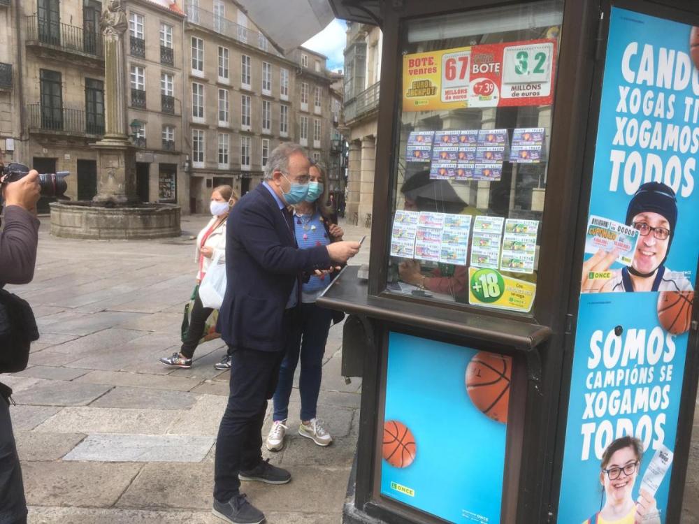 Sánchez Bugallo y la concejala d e Políticas Sociales compran el cupón en la compostelana Plaza de Cervantes