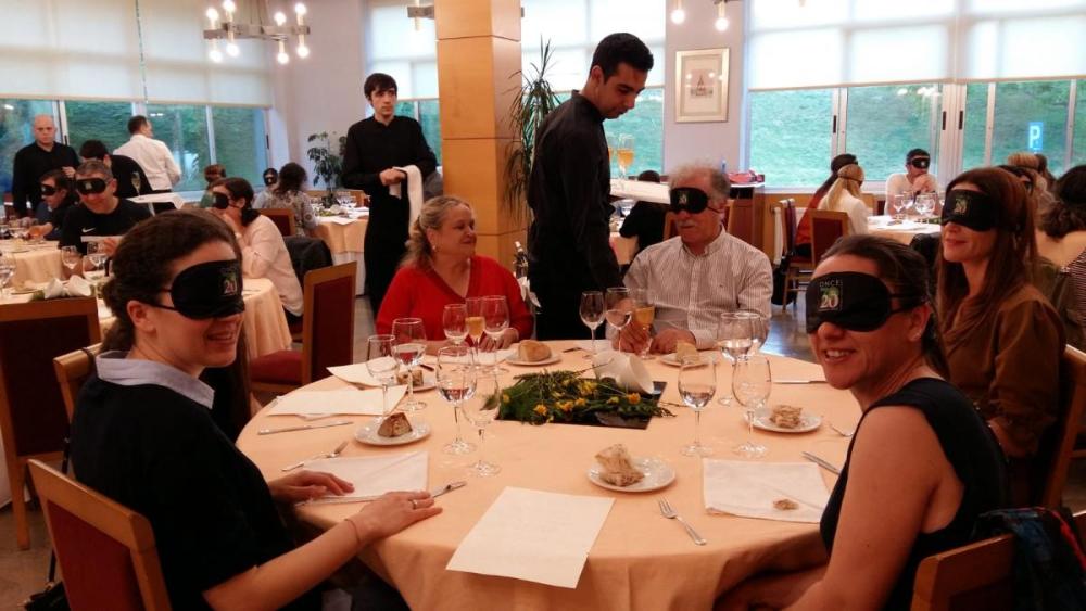 Vista xeral do comedor cunha mesa de afiliados á ONCE en primeiro termo