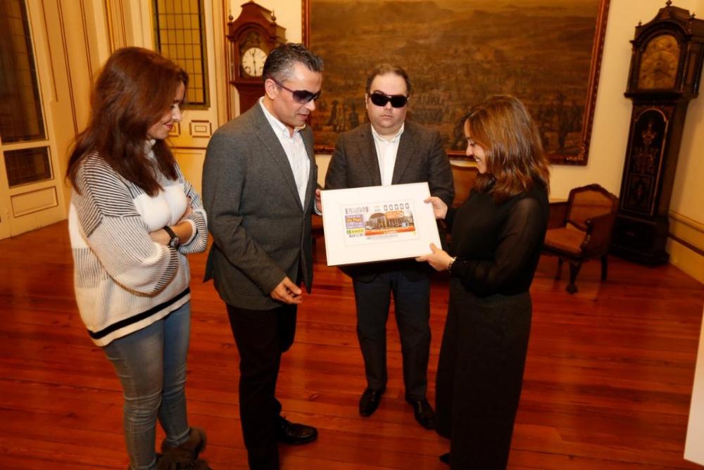 Na imaxe, momento da entrega dunha reproducción enmarcada do cupón da Praza de Lugo á alcaldesa de A Coruña
