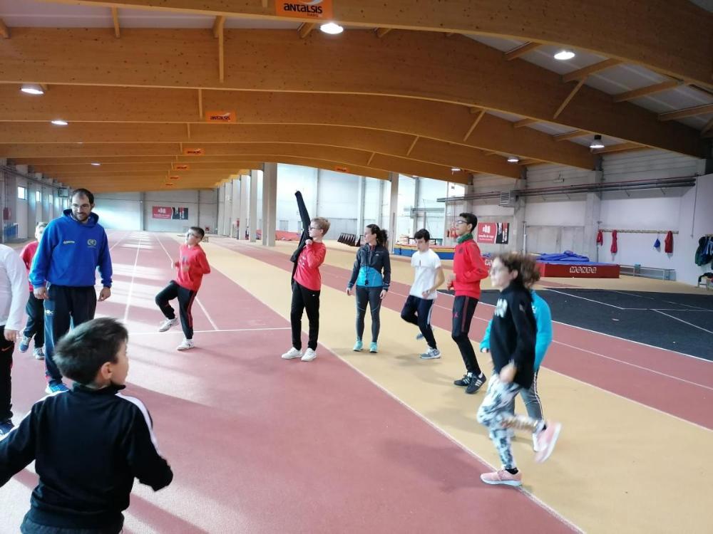 Un grupo de nenos e nenas participantes seguindo as indicacións dos  profesionais