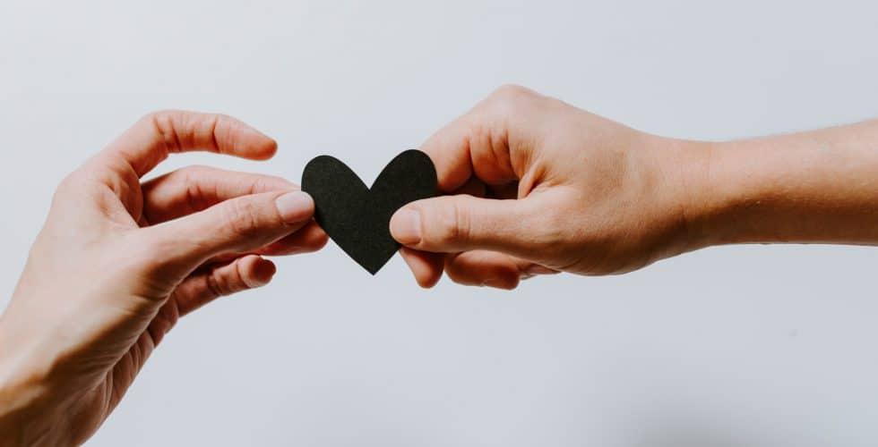 En la imagen se aprecian unas manos sosteniendo un corazón, que simboliza el objetivo comén de Inserta y la empresa Hack a Boss 