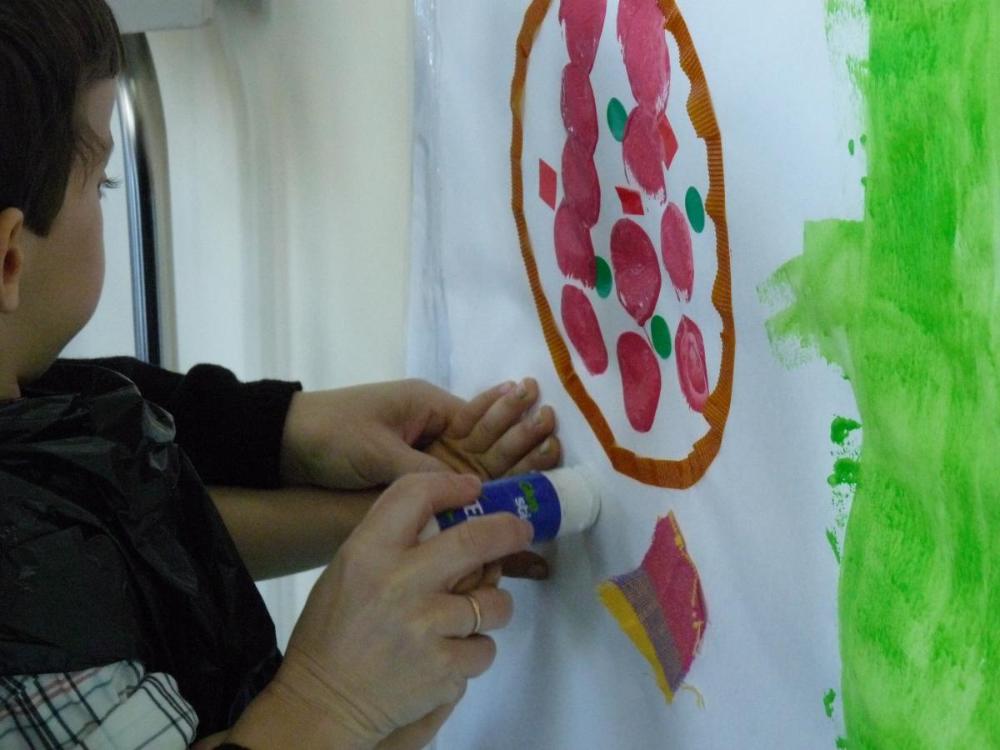 Un pequeño escolar pintando en el aula