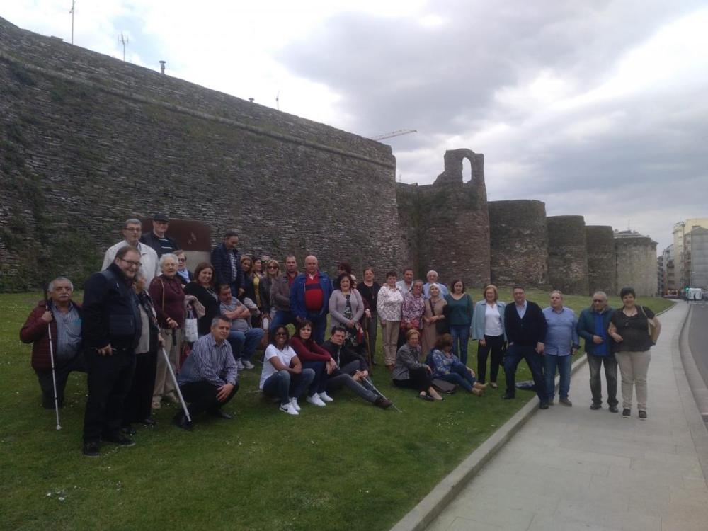 Afiliados y trabajadores de ONCE-Lugo posan ante la Muralla de la ciudad