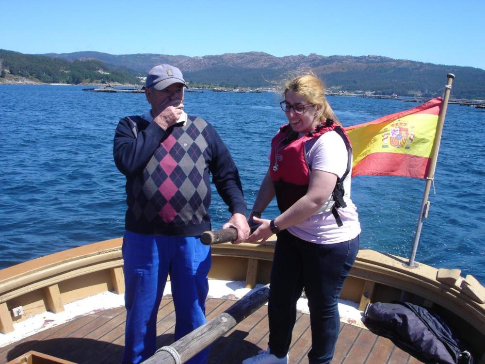 Unha moza afiliada experimenta o labor de guiar a embarcaci´pon baixo a supervisión dun mariñeiro