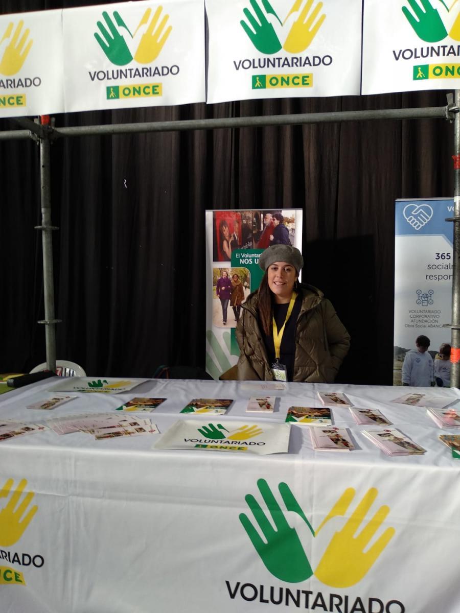 Imagen del stand de Voluntariado ONCE atendido por una joven voluntaria