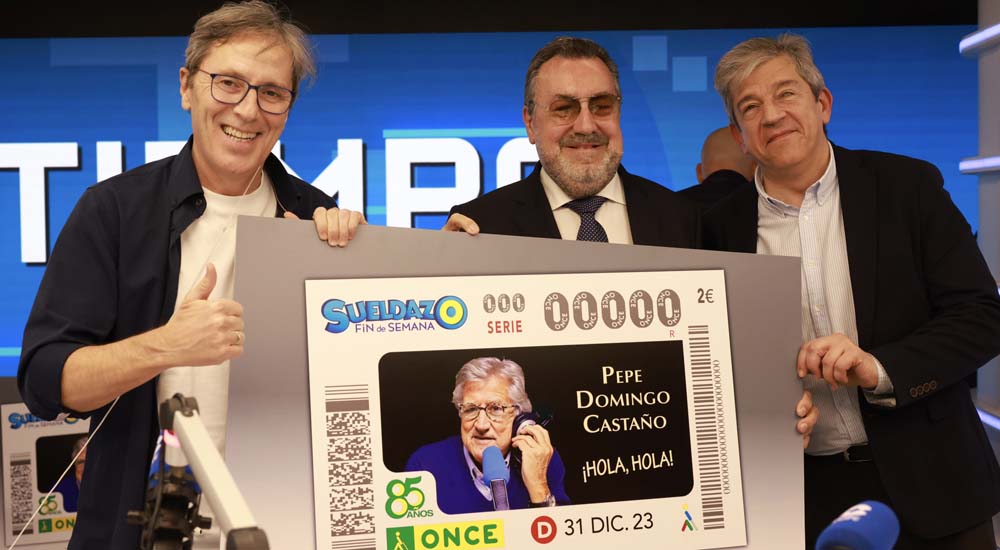 Paco González, Miguel Carballeda y Antonio Mayor, DIRCOI de la ONCE, con una copia gigante del cupón dedicado a Pepe Domingo Castaño
