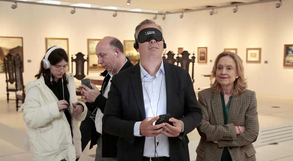 En primer plano, Rafael Domínguez y Ángeles Tilve, tras ellos José Ángel Abraldes, con las audioguías disfrutan de la exposición