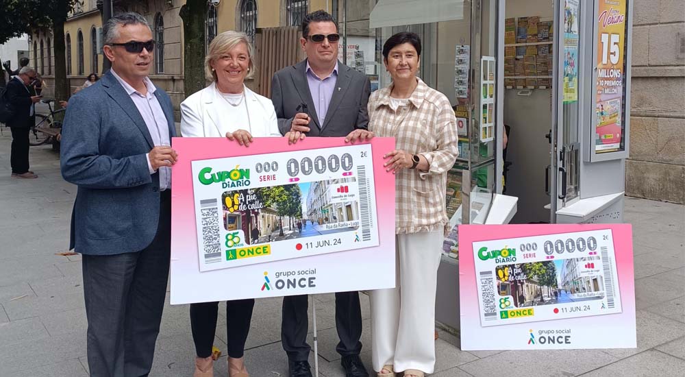 Foto de familia de la presentación del cupón de dicado a la Rúa da Raíña, Lugo, ante un quiosco de la ONCE