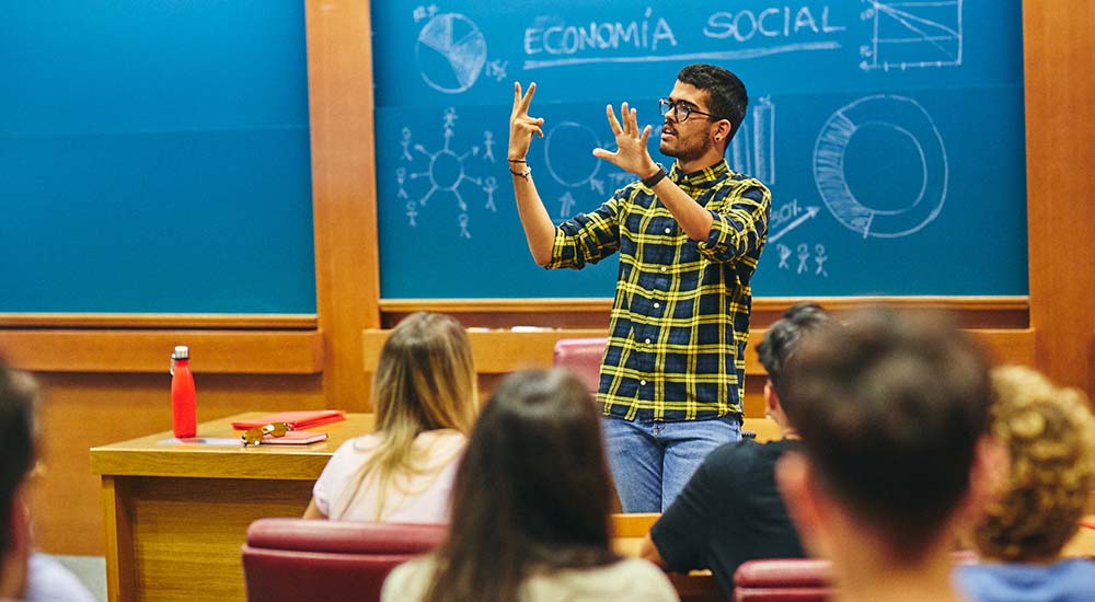 Aula con estudiantes y un profesor impartiendo clase