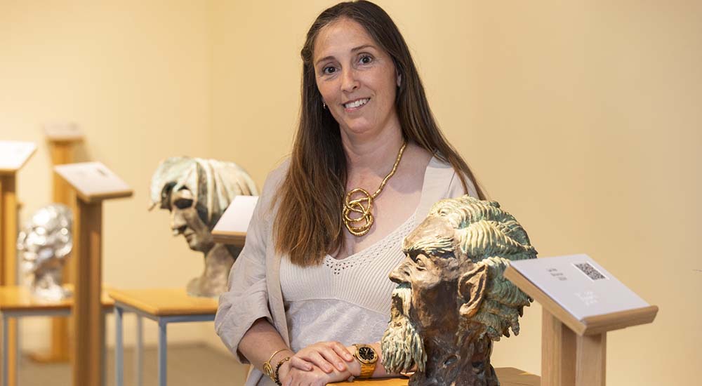 Cristina Rommel, entre dos de las esculturas de la serie Pecados capitales, que expone en el Museo Tiflológico de la ONCE