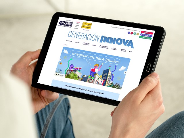 Unas manos sujetan una tablet en la que se visualiza la web del Concurso Escolar
