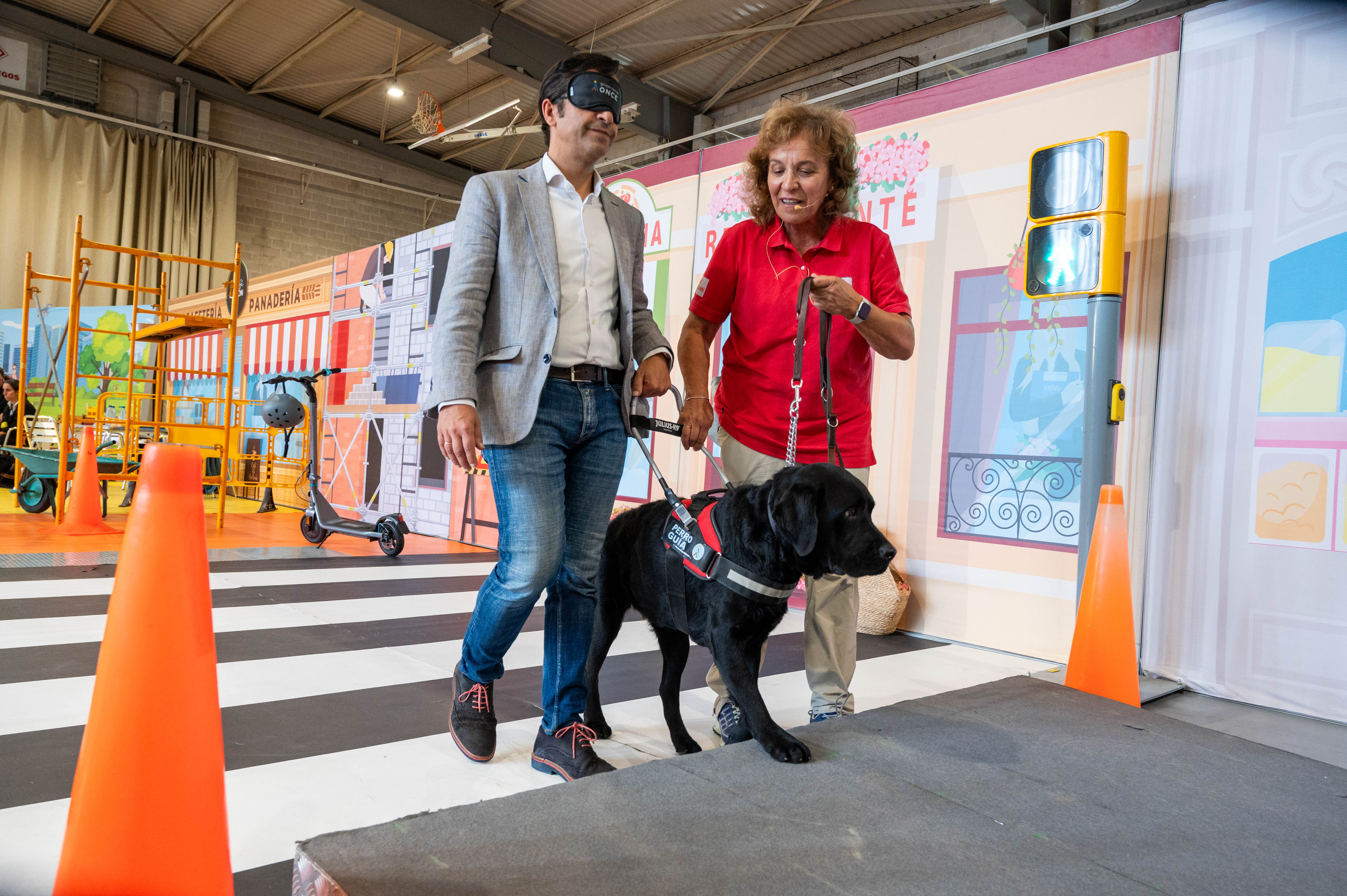 José Manuel Rey, alcalde de Ferrol, con antifaz, dejándose guiar por uno de los perros